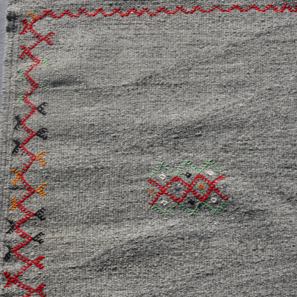 Minimalist Berber flatwoven rug with embroidery detail