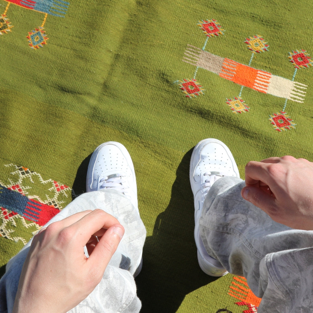 Minimal Moroccan Aknif rug with embroidered symbols on flatweave wool