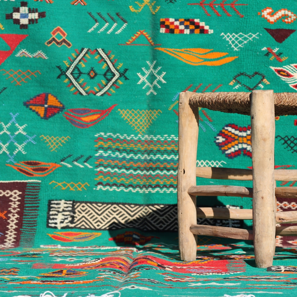 Aknif flatweave rug handwoven in Morocco with green wool and colorful Berber embroidery