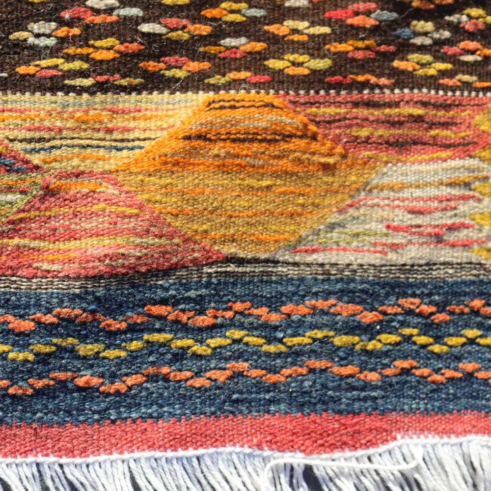 Macro detail of handwoven Moroccan wool rug featuring textured Berber tribal motifs in rich colors