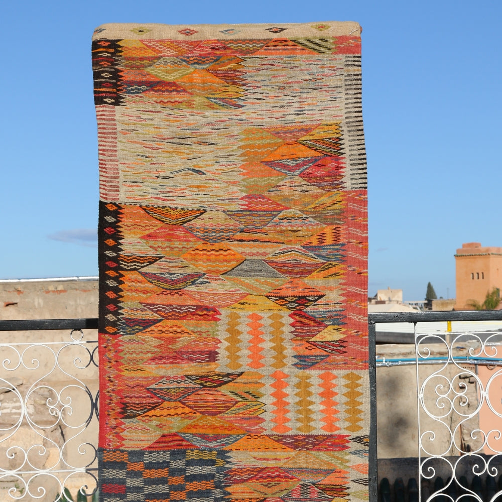 Handwoven Taznakht wool rug displayed outdoors with vibrant Berber geometric textile design