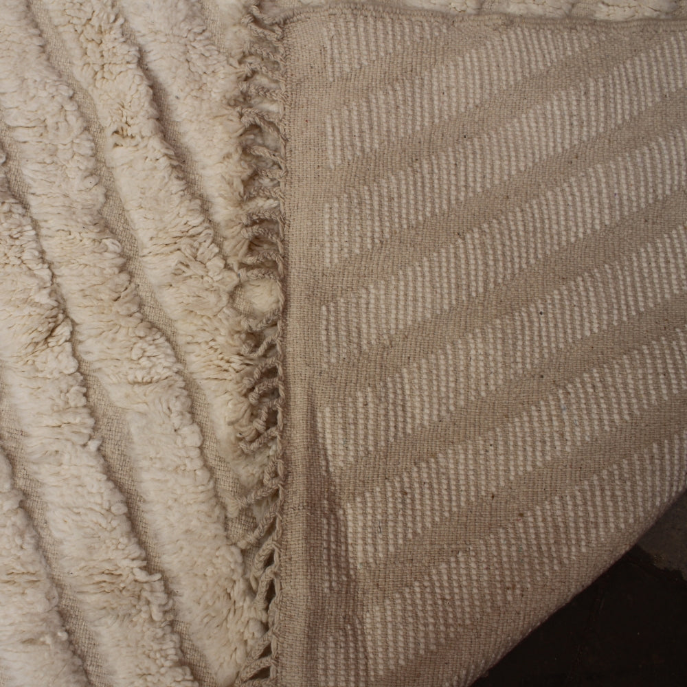 Close-up of a textured fabric with a frayed edge and woven pattern.