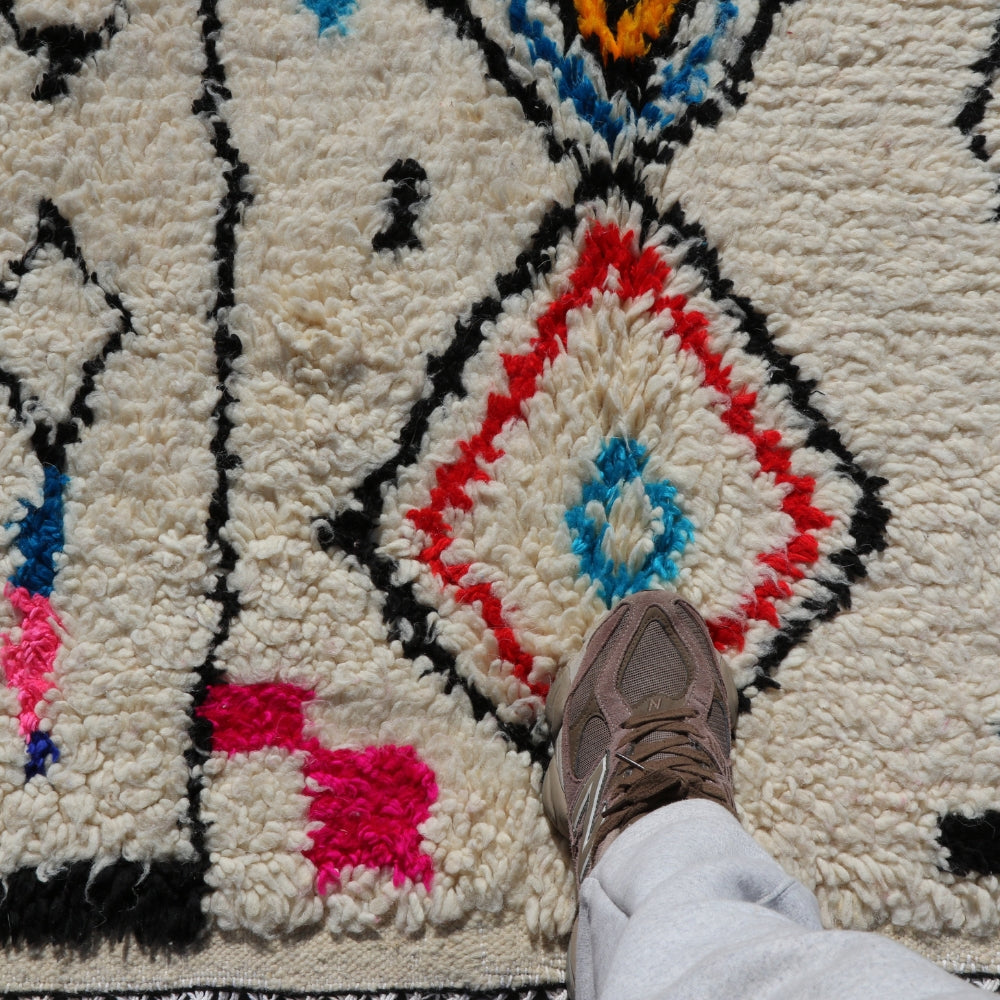 Handwoven Azilal wool rug with plush ivory pile, colorful abstract berber patterns shown in real scale