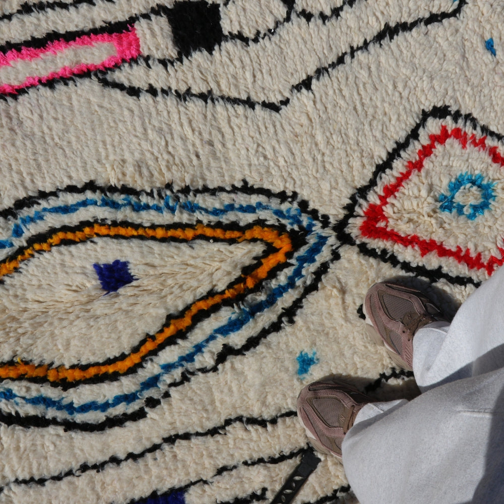 Close up of Azilal rug diamond motif, hand knotted wool with expressive berber design and vibrant color accents