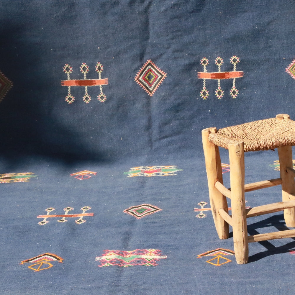 Moroccan Aknif kilim rug featuring hand embroidery on deep blue background