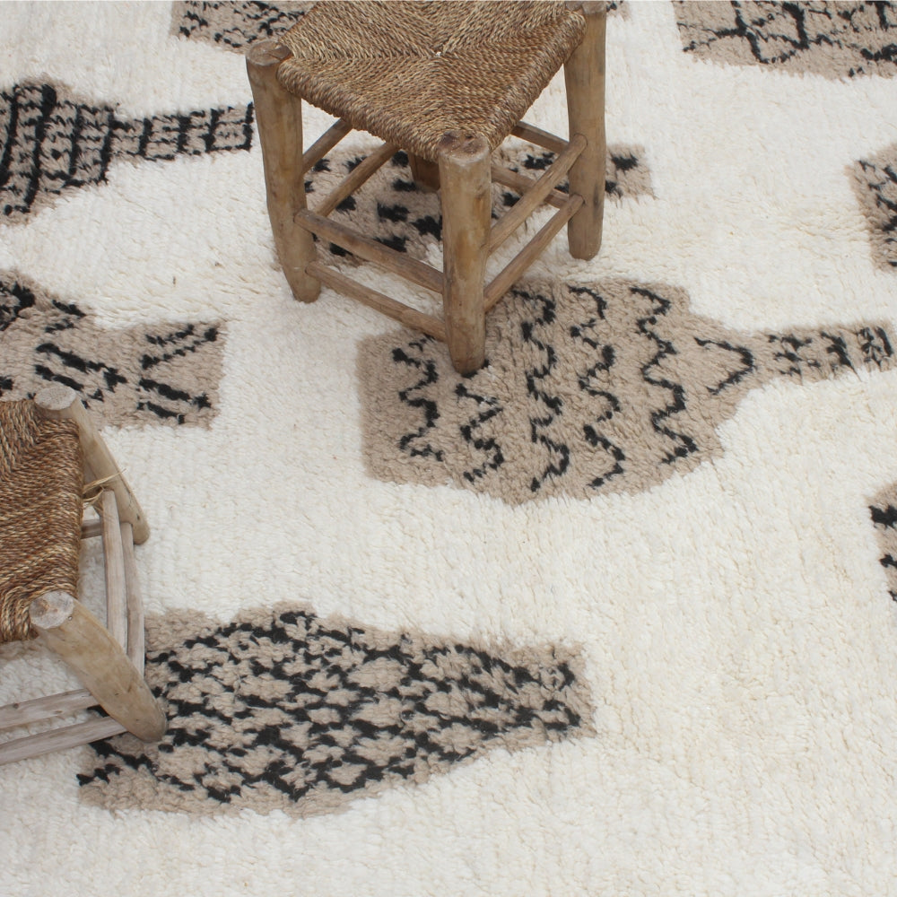 Patterned rug with a wooden chair and woven basket on a neutral background