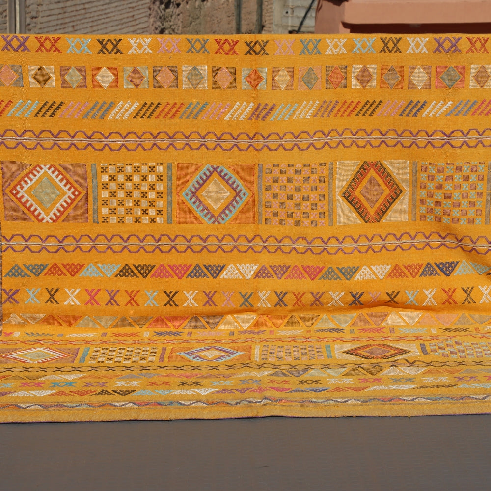 Handwoven Moroccan cactus silk rug with graphic flatweave pattern in warm yellow tones