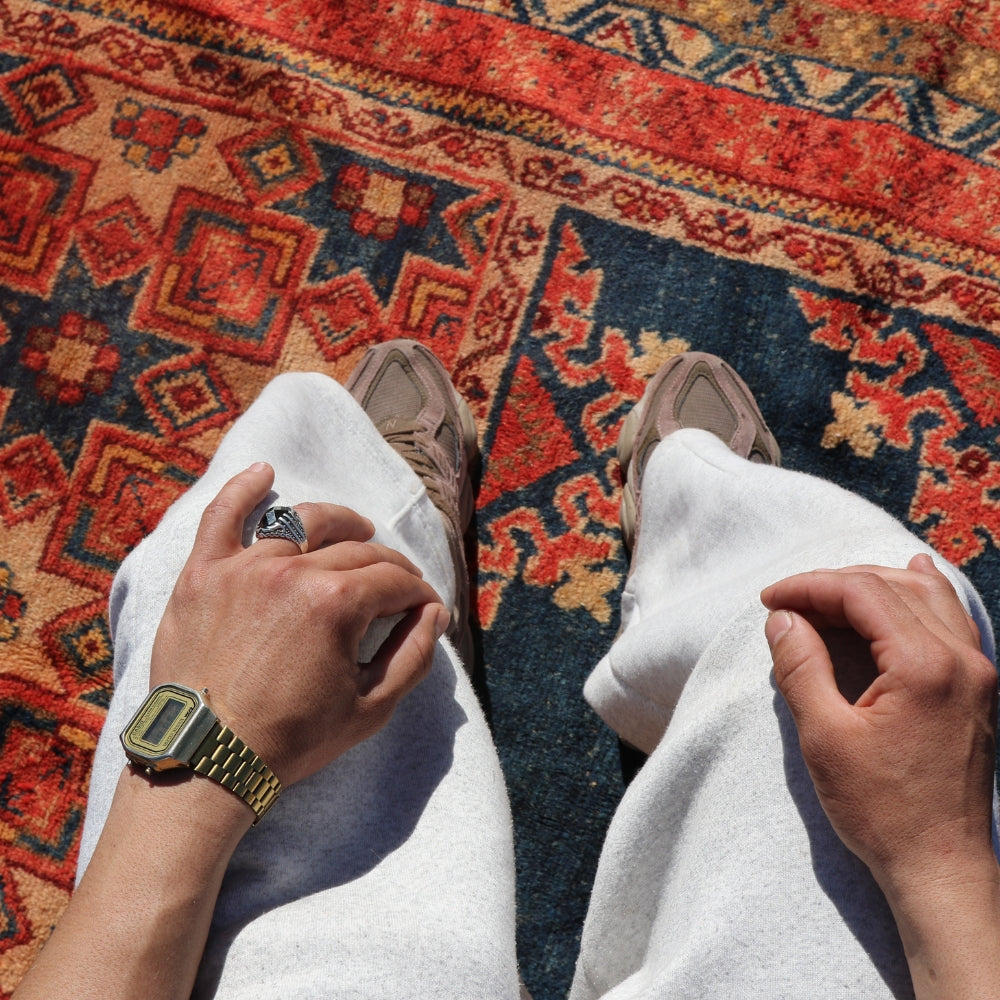 Close up of vintage Taznakht rug texture with natural wool patina and tribal symbols