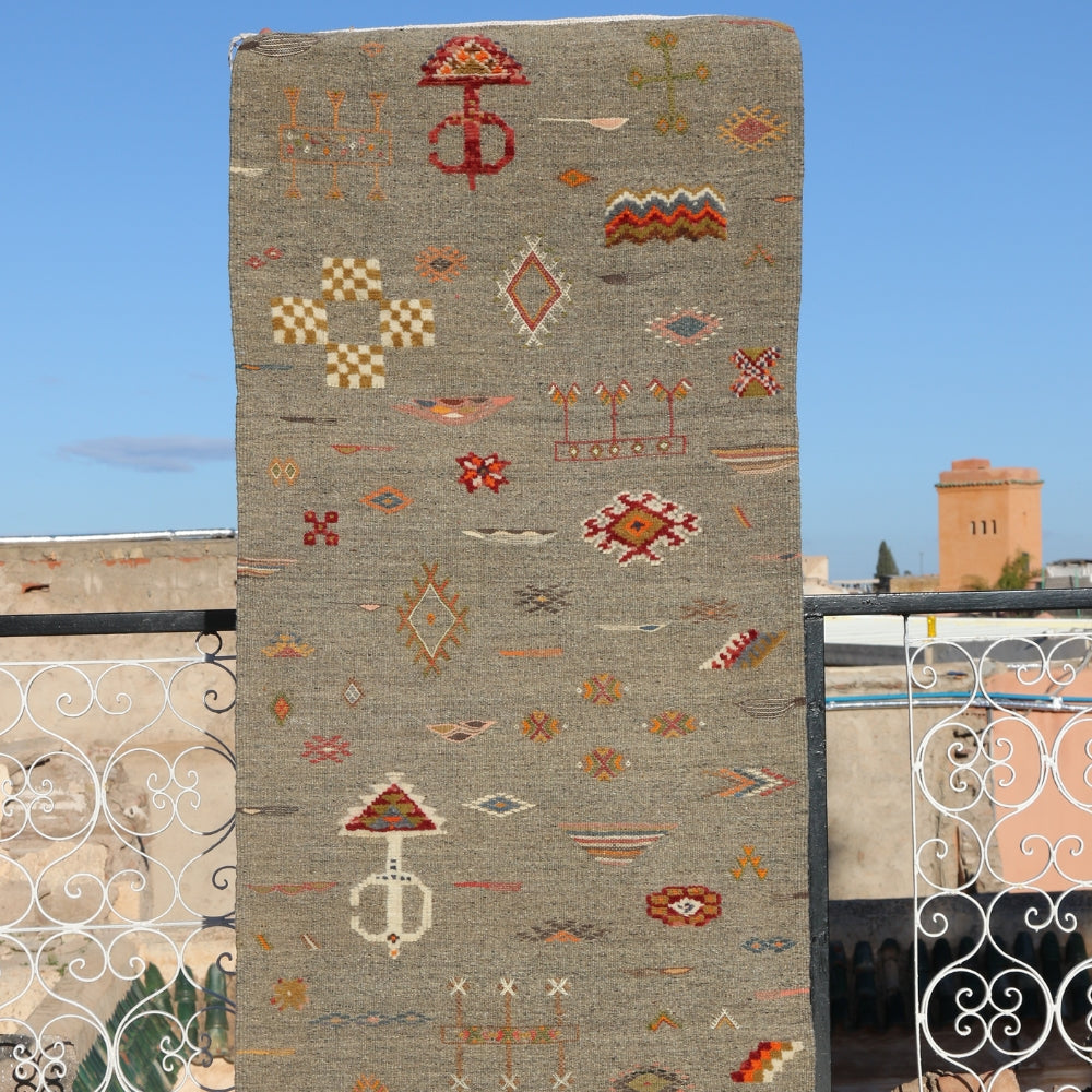 Handwoven Akhnif Berber rug displayed outdoors with tribal Moroccan motifs