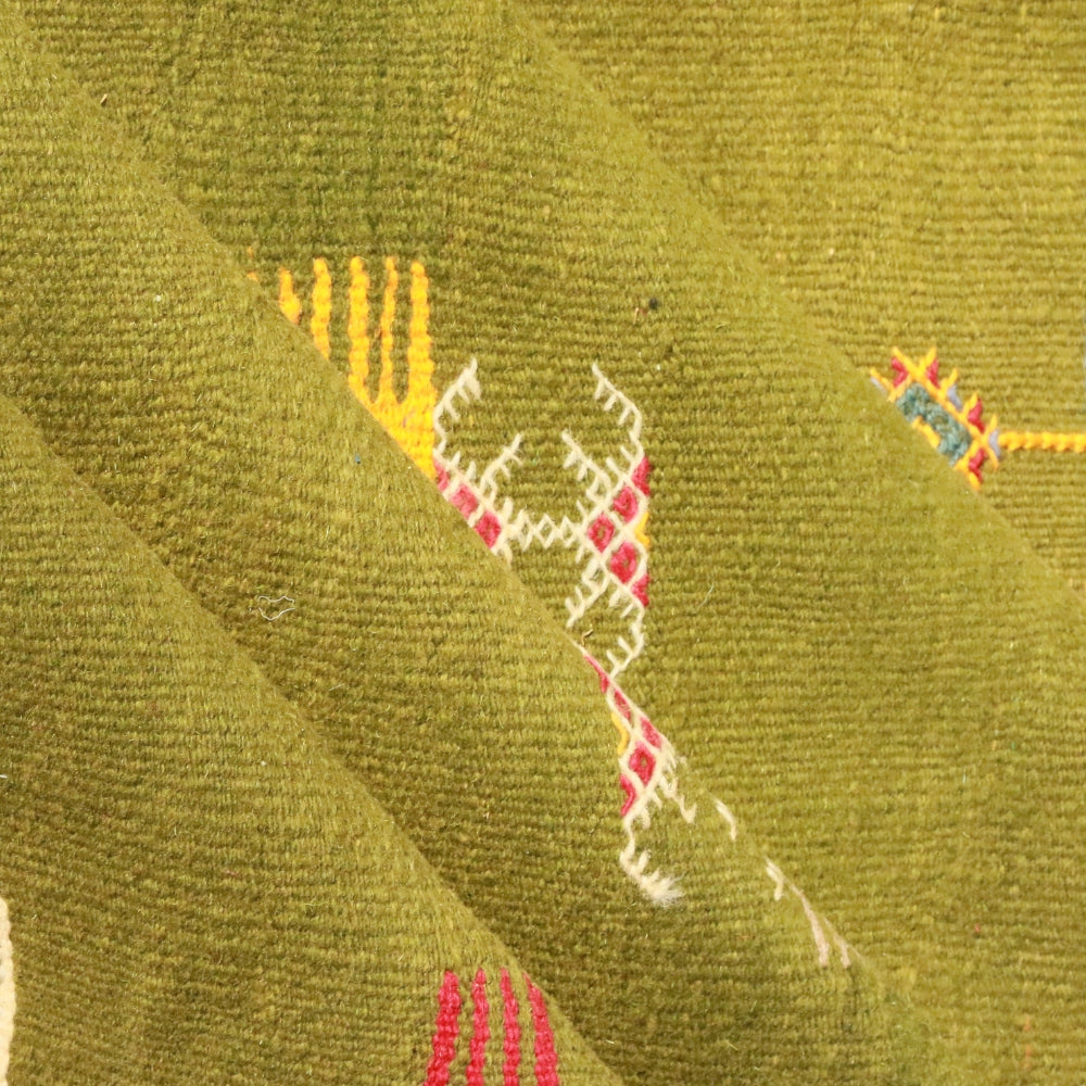 Detail of hand embroidery on green Aknif Moroccan flat rug