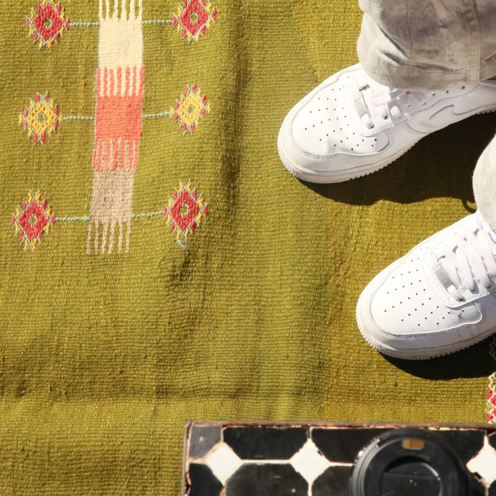 Textured surface of olive green Aknif flatwoven wool rug