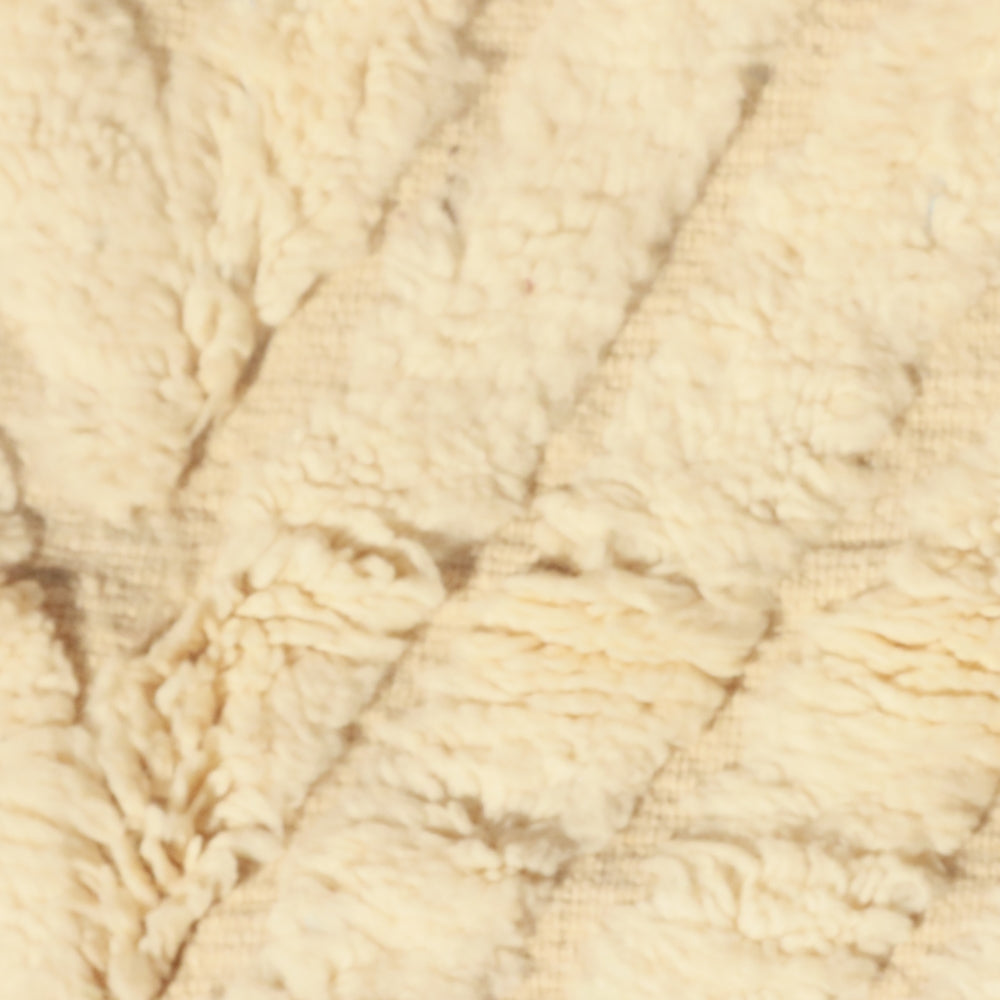 Close-up of ivory wool texture carved beni ourain rug