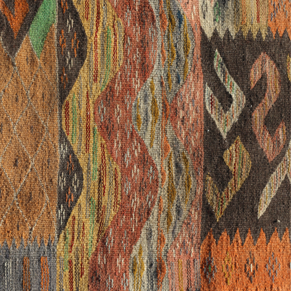 Handwoven Moroccan Taznakht rug displayed outdoors with vibrant patchwork tribal patterns