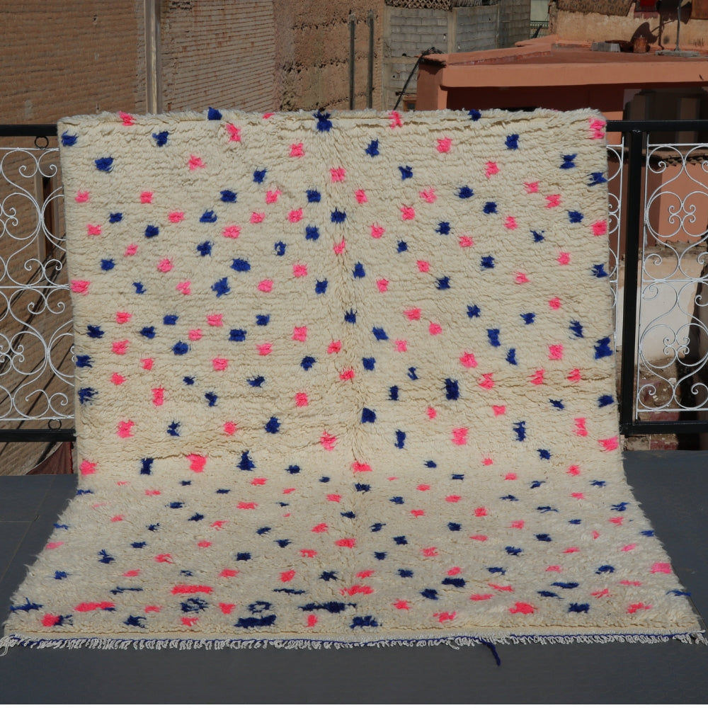 Contemporary Beni Ourain rug handwoven in Morocco, ivory wool with subtle pink and blue accents, plush berber pile texture