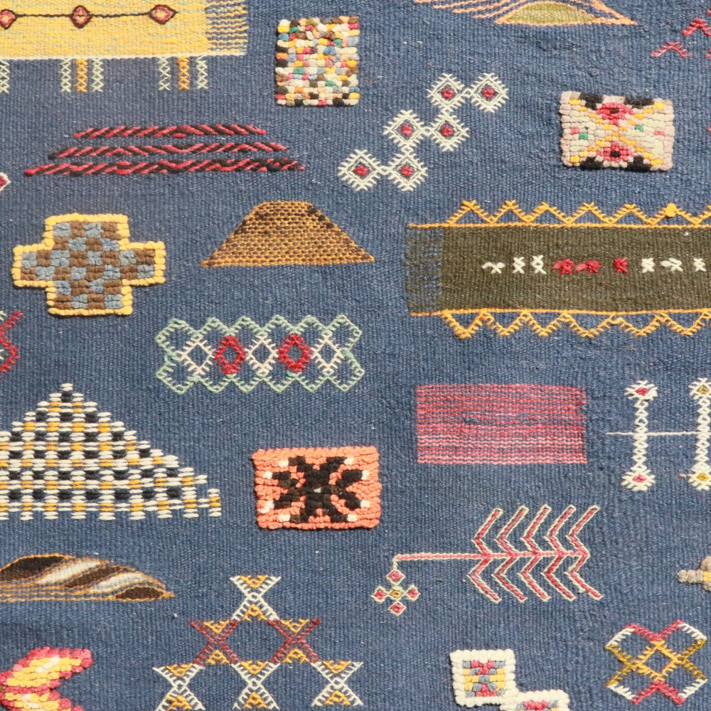 Moroccan Aknif kilim rug featuring hand embroidery on deep blue background
