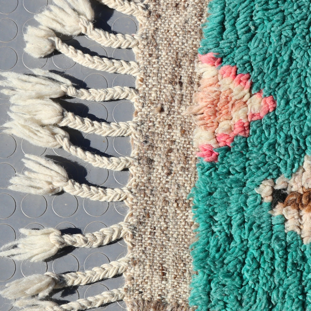 Close up of a handwoven Moroccan Azilal rug showing thick natural wool and symbolic patterns