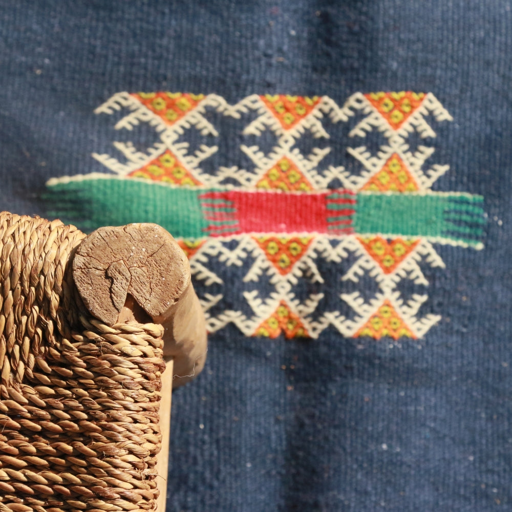 Close up on a minimalist Moroccan Aknif rug with handwoven flatweave and embroidery