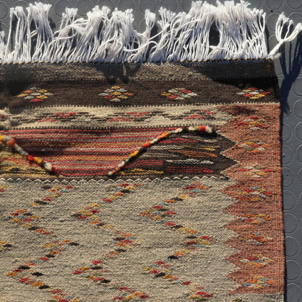 Artisan Moroccan wool rug with tribal flatwoven texture and warm earthy patchwork patterns