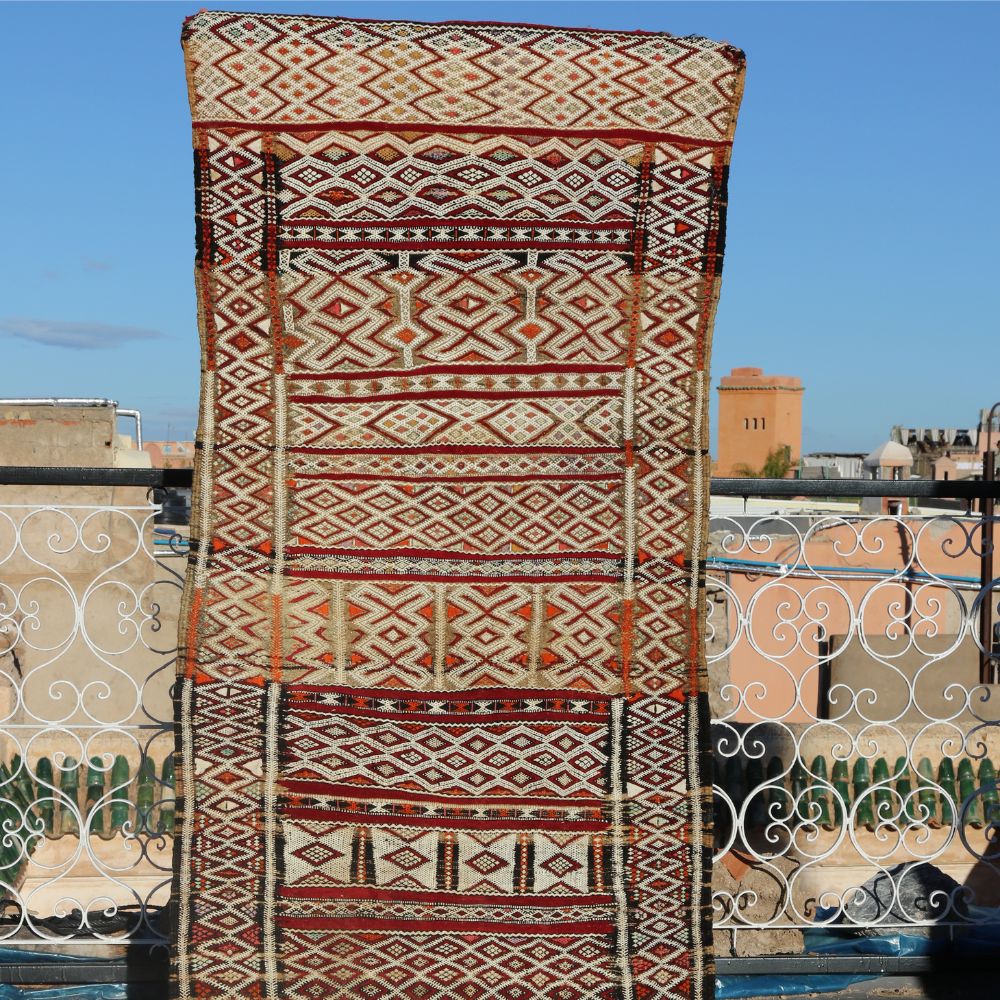 Handwoven Zamour wool rug displayed outdoors featuring traditional Moroccan tribal patterns